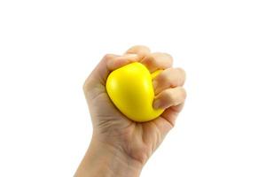 mano de mujer apretando una pelota antiestrés sobre fondo blanco foto