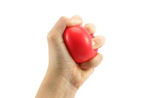 Woman hand squeezing a stress ball  on white background photo