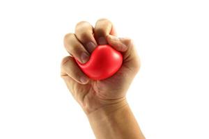 Hand squeezing a stress ball  on white background photo