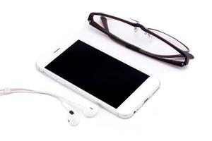 Snart phone  and headphone,glasses on white table photo