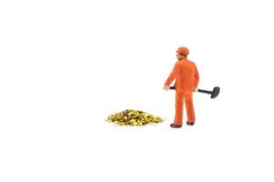 Miniature people working in gold mine isolated on white background photo