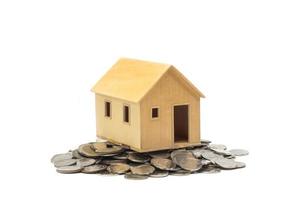 pequeña casa de pie sobre monedas. el concepto de compra de vivienda. foto