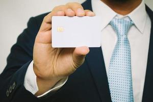 hombre que sostiene la tarjeta de crédito en blanco foto