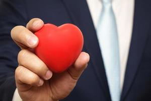 red heart in businessman hand photo