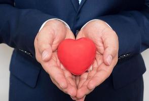 red heart in businessman hand photo