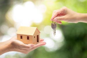 women hand holding a model home and a key,Buying a new house concept photo