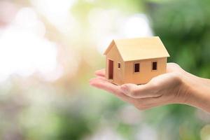 Woman holding home model, loan concept photo