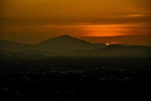 Night natural scene, Good night The golden light from the setting sun, there is still a beautiful golden light and mountains in the shadows. The light from light bulbs in homes becomes more prominent photo