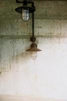 the old lamp attached on the mortar wall. photo