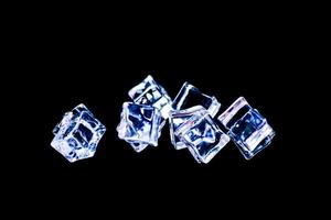 Ice cubes on a black background. ice falling on a black background for use as an illustration in a project photo