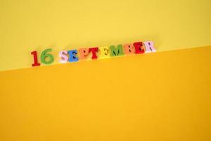 September 16 on a yellow, paper background with space for text. photo