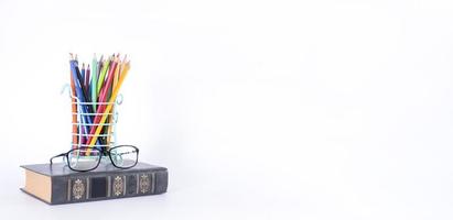 A stack of books, study guides, textbooks, glasses, and pencils in a text copy holder. photo