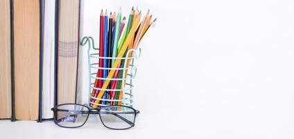 A stack of books, study guides, textbooks, glasses, and pencils in a text copy holder. photo