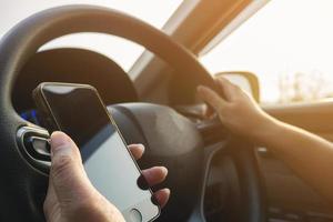 Lady using mobile phone while driving car dangerously photo