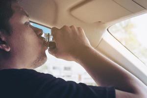 el hombre que toma una bebida saludable mientras conduce se preocupa por un refresco despierto y una conducción robusta: conduzca de forma segura con algún concepto de bebida refrescante foto