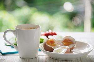 huevos cocidos con ensalada de pepino fresco y juego de desayuno con taza de café - vista superior concepto de comida para el desayuno foto