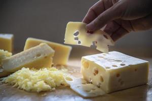 Woman preparing cheese for cook using cheese grater in the kitchen - people making food with cheese concept photo