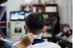 Man is cut his hair in barber shop - people in hairdresser beauty salon concept photo