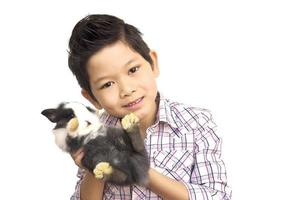 Asian kid playing with lovely baby rabbit isolated over white photo