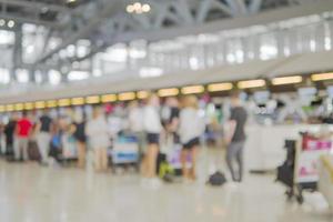 imagen borrosa de la larga cola de pasajeros esperando el check-in en los mostradores de check-in del aeropuerto foto