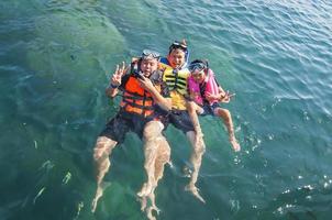 Three guys floating happily in the sea water photo