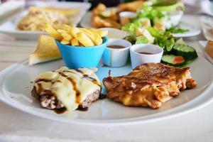 Juego de comida de bistec de cerdo y pollo de pescado - comida fresca limpia en el concepto de mesa foto