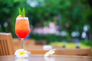 nombre de la receta del cóctel mai tai o mai thai en todo el mundo el cóctel favorito incluye ron, jugo de lima, jarabe de horchata y licor de naranja - bebida de alcohol dulce con flores en el jardín, concepto de vacaciones relajantes foto