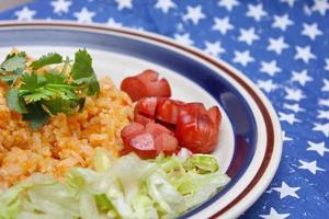 Fried rice with fried sausage served in a creamy dish with tomatoes and cucumbers. photo