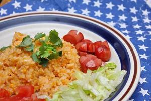 Fried rice with fried sausage served in a creamy dish with tomatoes and cucumbers. photo