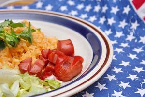 Fried rice with fried sausage served in a creamy dish with tomatoes and cucumbers. photo