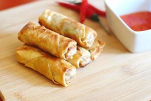Spring rolls with chili sauce on the wooden background photo