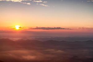 Scenic view of beautiful sunrise and mist over the mountains photo