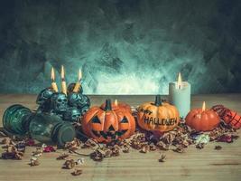 Halloween pumpkins with candlelight and skulls on dark background.Vintage tone photo