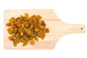 Yellow raisins on wooden tray. photo