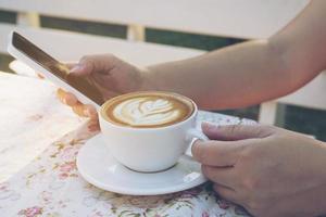 Lady using mobile white drinking coffee photo