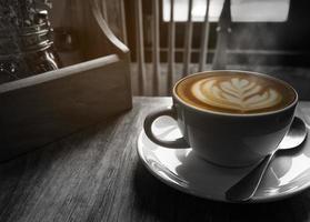 Hot coffee cup with warm morning light window, black and white tone with partial color layer picture photo