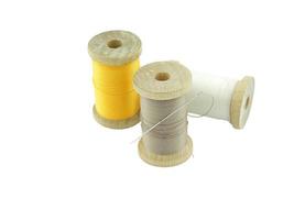 Isolated wooden spools of thread with a needle photo