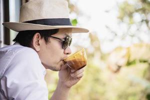 hombre asiático casual bebe café caliente felizmente en la naturaleza - gente con café en el concepto de naturaleza foto