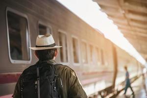 Travel man wait train at platform - people vacation lifestyle activities at train station transportation concept photo