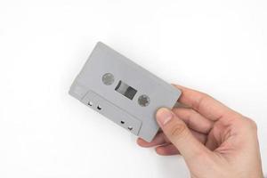 Hand holding cassette tape on white background. photo