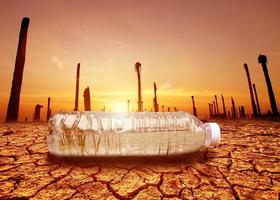 concept of water scarcity Drought due to global warming. Water bottles placed in drought and broken soil areas photo