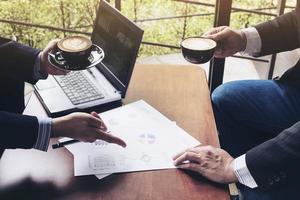 Two businessman discussing their chart in coffee shop photo