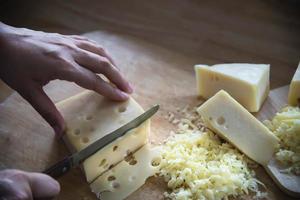 mujer preparando queso para cocinar usando rallador de queso en la cocina - gente haciendo comida con concepto de queso foto