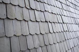 exterior details of the roof of a house made of ironwood, dark gray background texture photo