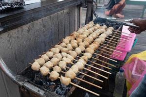 selective focus on grilled meatballs skewered with bamboo and sold at culinary festivals photo
