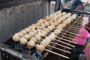 selective focus on grilled meatballs skewered with bamboo and sold at culinary festivals photo