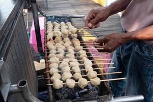 selective focus on grilled meatballs skewered with bamboo and sold at culinary festivals photo