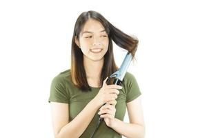 La mujer de belleza cuida su cabello usando una camilla de cabello aislada sobre fondo blanco - personas con concepto de cuidado del cabello foto