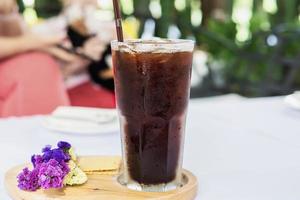 Cold americano glass on white cloth cover table - cold relax beverage concept photo