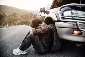 Man try to fix a car engine problem on a local road Chiang mai Thailand - people with car problem transportation concept photo